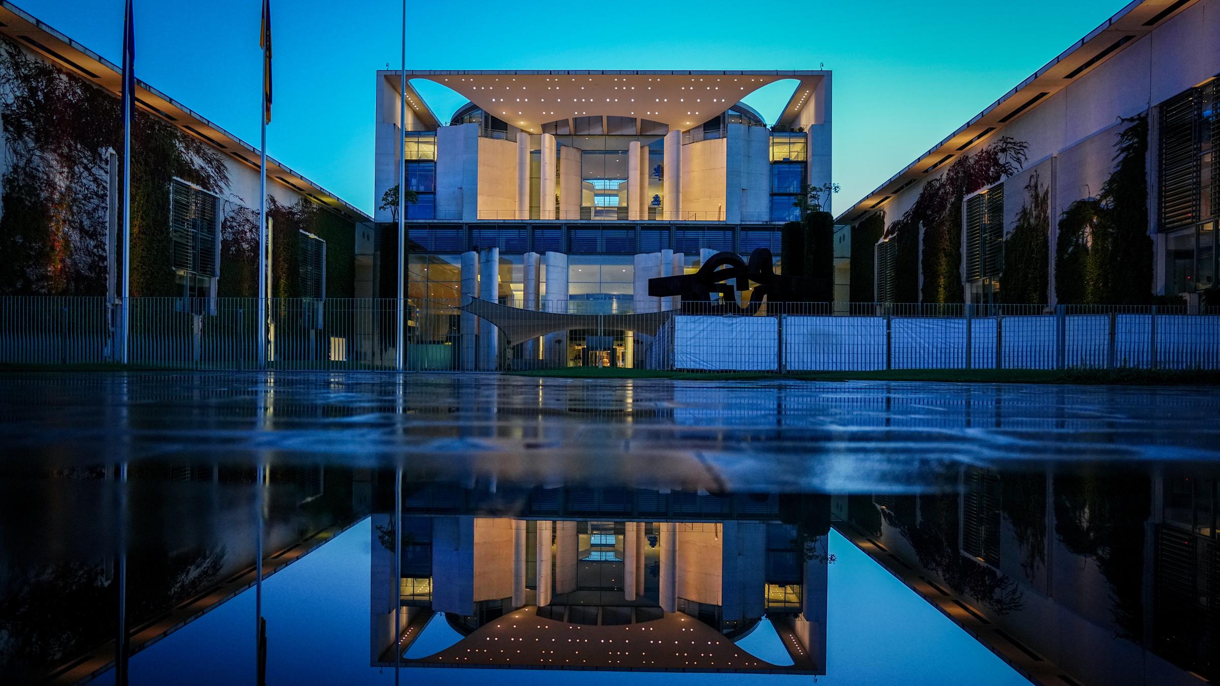  Das Bundeskanzleramt spiegelt sich am Abend in einer Pfütze.