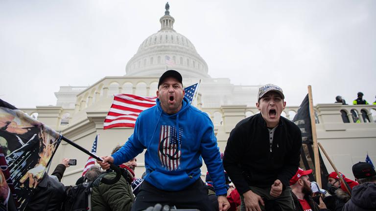 Trump-Anhänger vor dem Kapitol mit QAnon-Pullover.