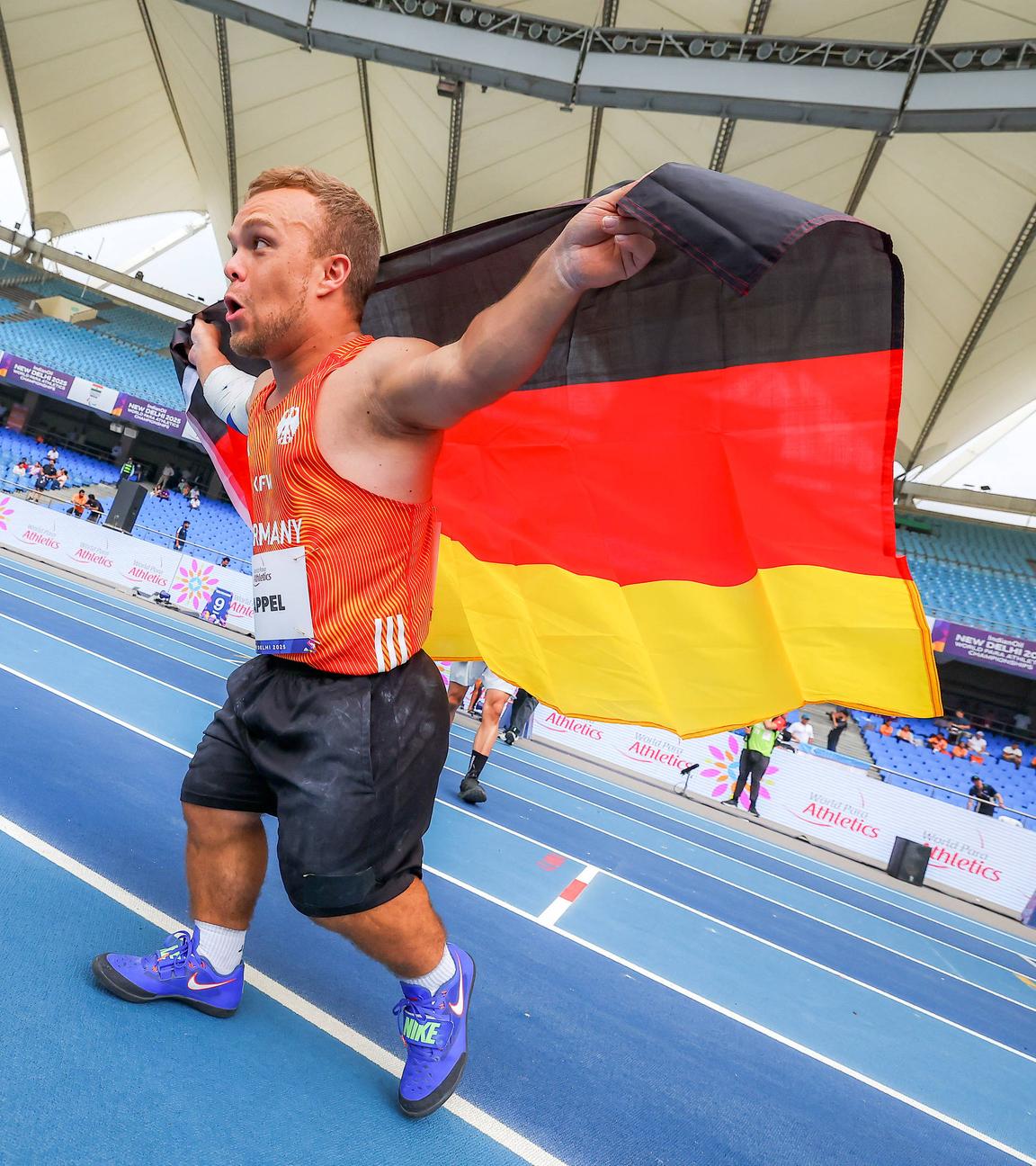 Niko Kappel läuft jubelt auf der Tartanbahn und hält die Deutschland-Fahne hinter dem Rücken