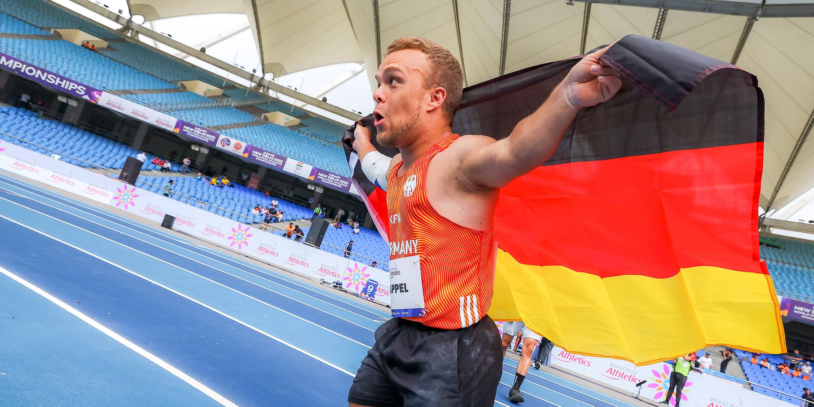 Niko Kappel läuft jubelt auf der Tartanbahn und hält die Deutschland-Fahne hinter dem Rücken