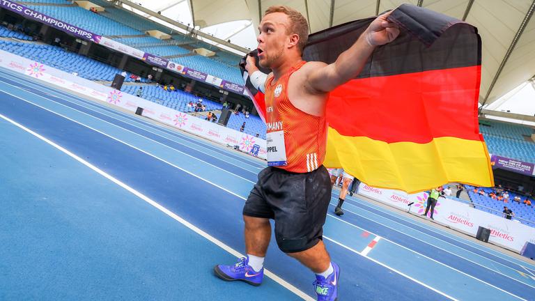 Niko Kappel läuft jubelt auf der Tartanbahn und hält die Deutschland-Fahne hinter dem Rücken
