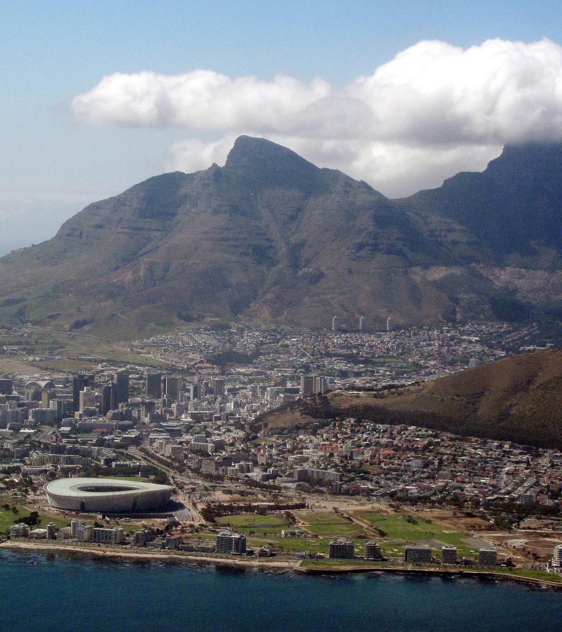 Es ist eine Drohnenaufnahme von Kapstadt und dem Tafelberg zu sehen.