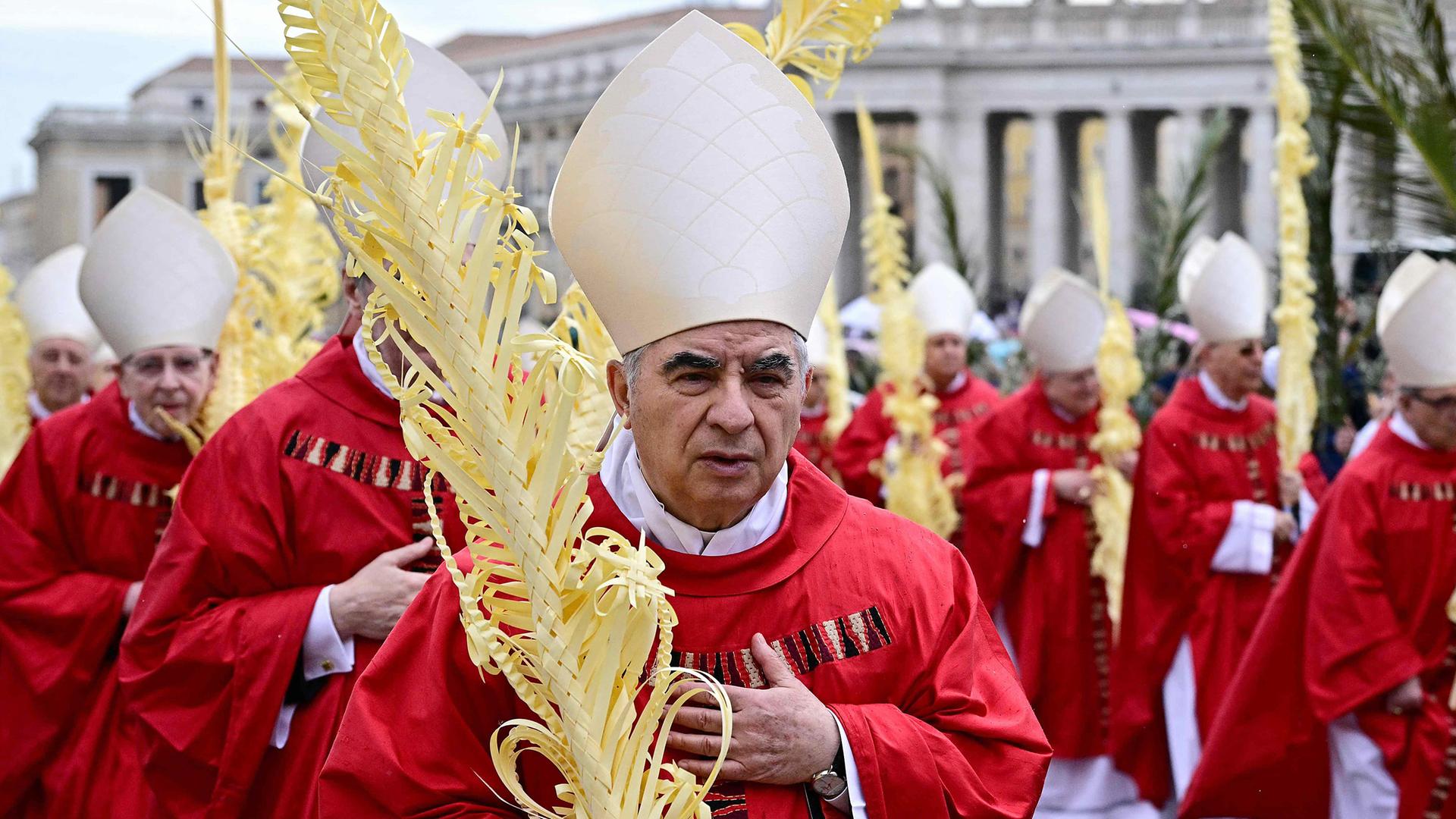 Kardinal Angelo Becciu geht am 13. April 2025 während einer Messe zum Palmsonntag auf dem Petersplatz im Vatikan in Prozession