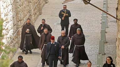 Katholische Gläubige gehen durch die Altstadt Jerusalems.