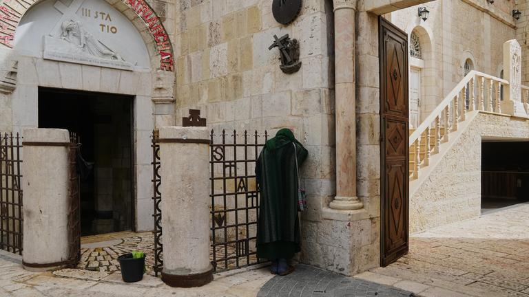 Ein christlicher Pilger betet am Karfreitag, dem 3. April 2026, in der weitgehend menschenleeren Altstadt Jerusalems aufgrund von Einschränkungen im Zusammenhang mit dem Iran-Krieg. 