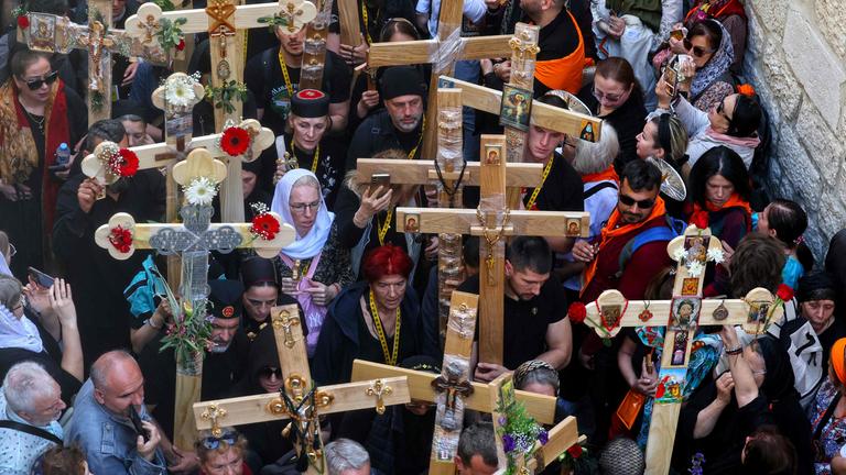 Chrisians carrying crosses walk through Jerusalem's Old City on their way to the Holy Sepulcre church during the Orthodox Good Friday procession.