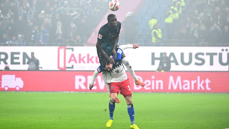 Karim Coulibaly (Werder Bremen) stützt sich auf Rayan Philippe (HSV), um zum Kopfball zu kommen