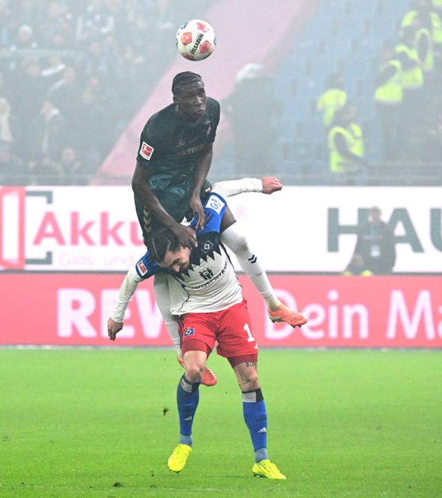 Karim Coulibaly (Werder Bremen) stützt sich auf Rayan Philippe (HSV), um zum Kopfball zu kommen