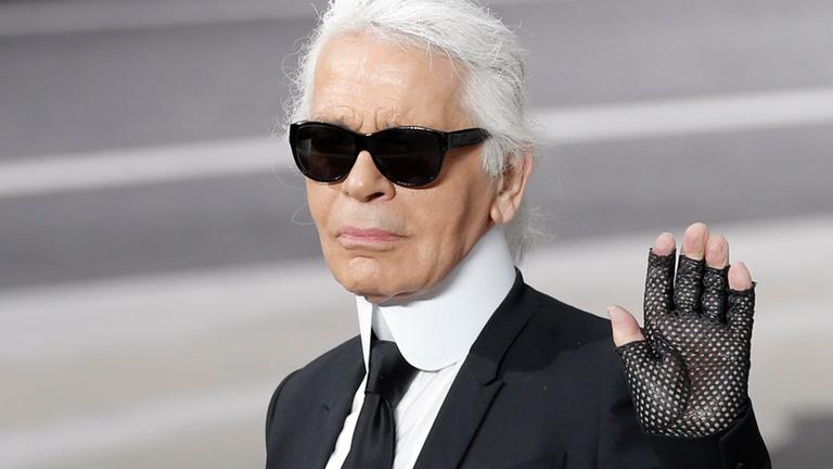 05.03.2013, Frankreich, Paris: Karl Lagerfeld hebt die Hand, als er den Applaus nach der Vorstellung seiner Herbst/Winter 2013-2014 Kollektion für Chanel entgegennimmt.