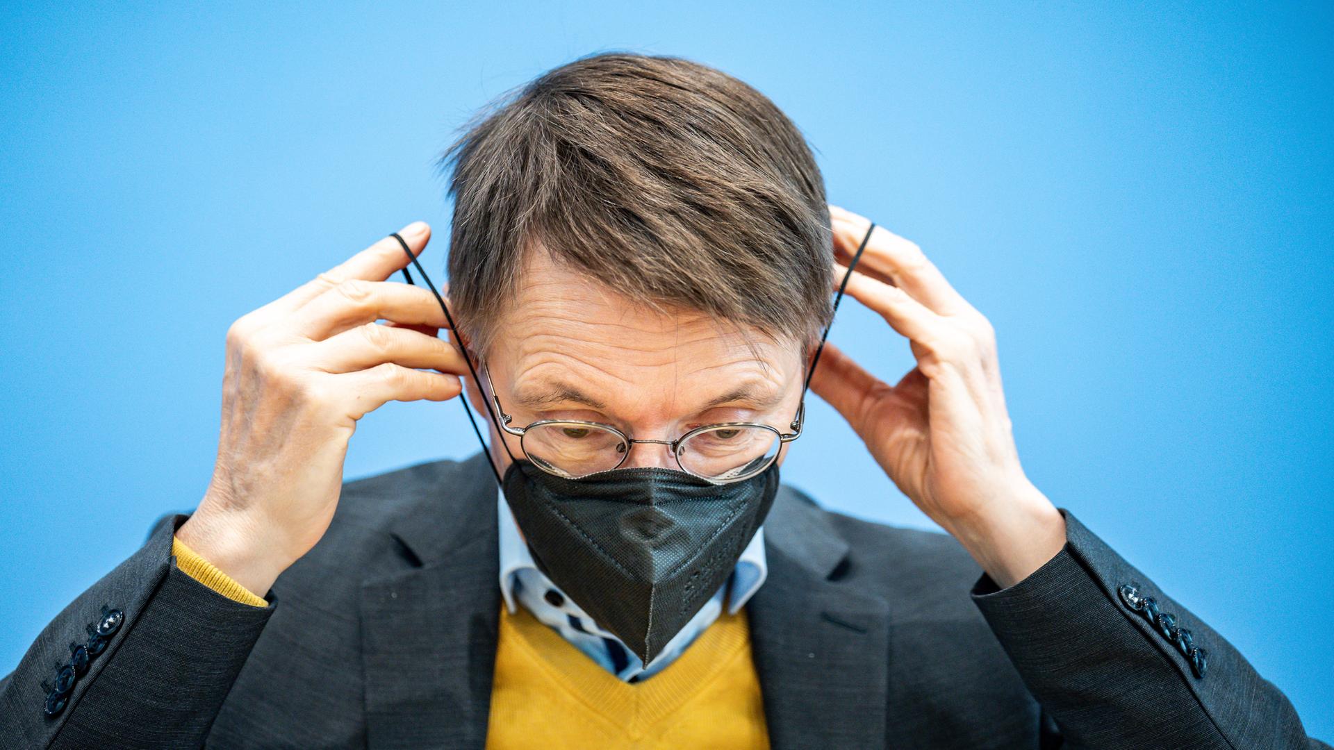 Berlin: Karl Lauterbach zieht Mund-Nasen-Schutzmaske auf, Archivbild