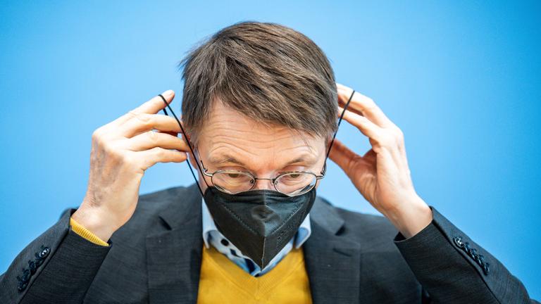 Berlin: Karl Lauterbach zieht Mund-Nasen-Schutzmaske auf, Archivbild