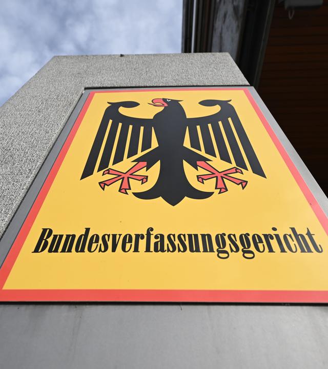 Ein Hinweisschild mit Bundesadler und dem Schriftzug Bundesverfassungsgericht, aufgenommen vor dem Bundesverfassungsgericht. 