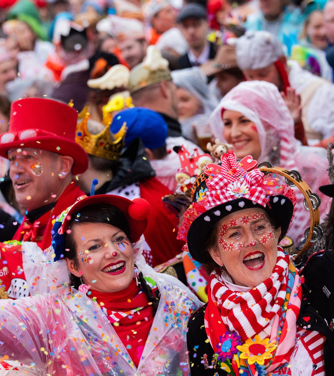 Verkleidete Menschen werfen Konfetti in die Luft