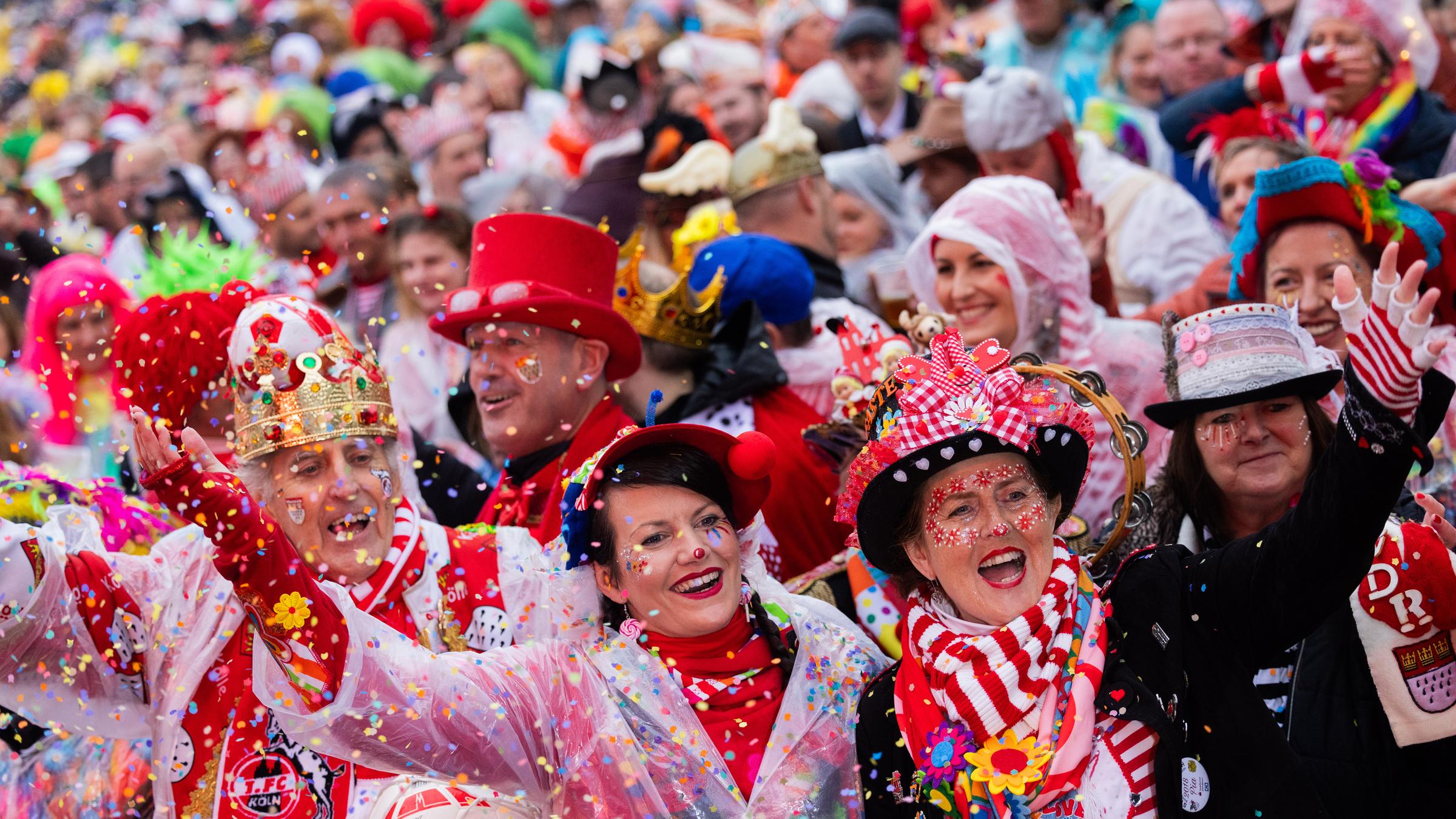 Verkleidete Menschen werfen Konfetti in die Luft