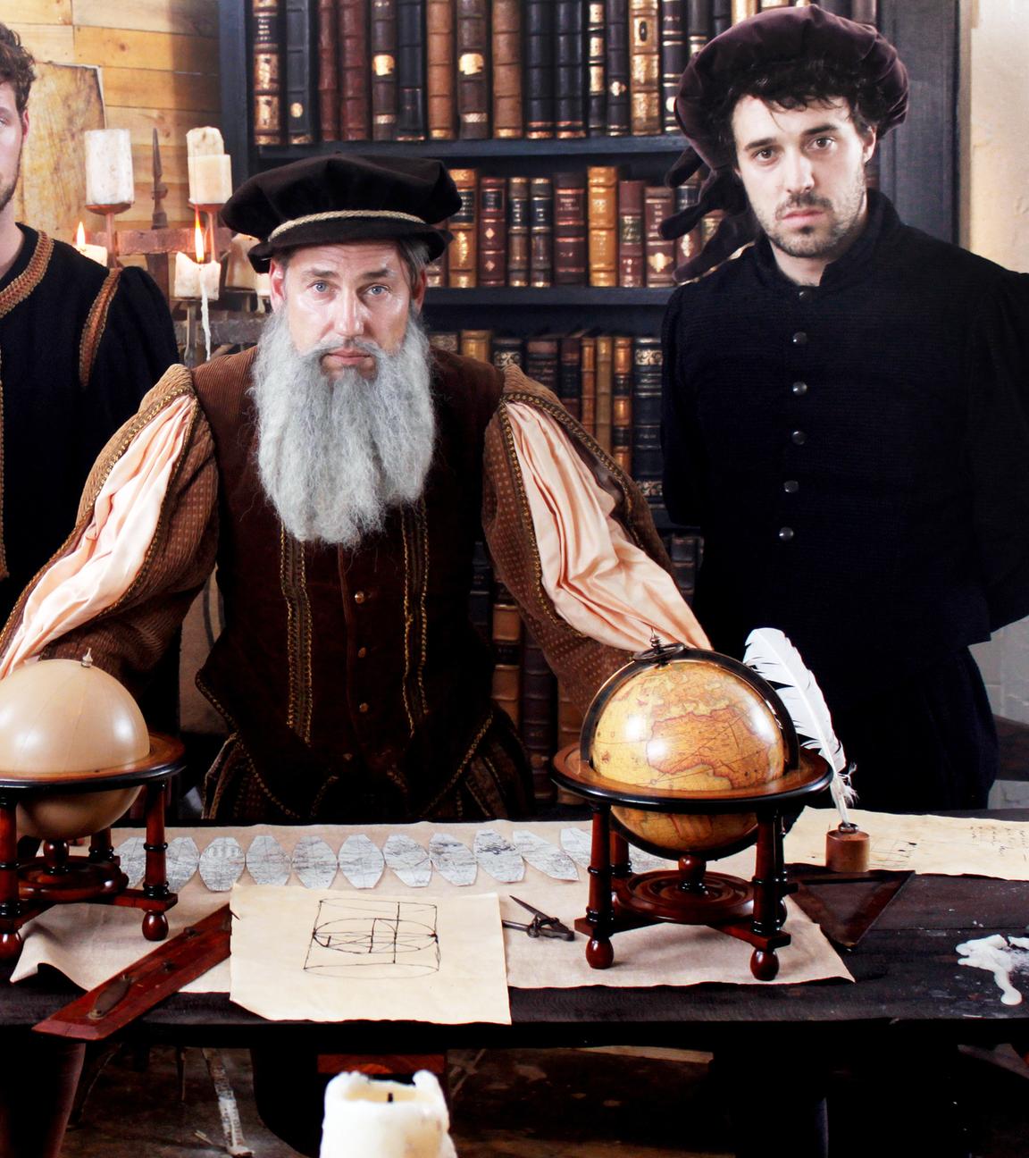Gerhard Mercator steht mit drei Gehilfen an einem Arbeitstisch in seiner Kartenwerkstatt.