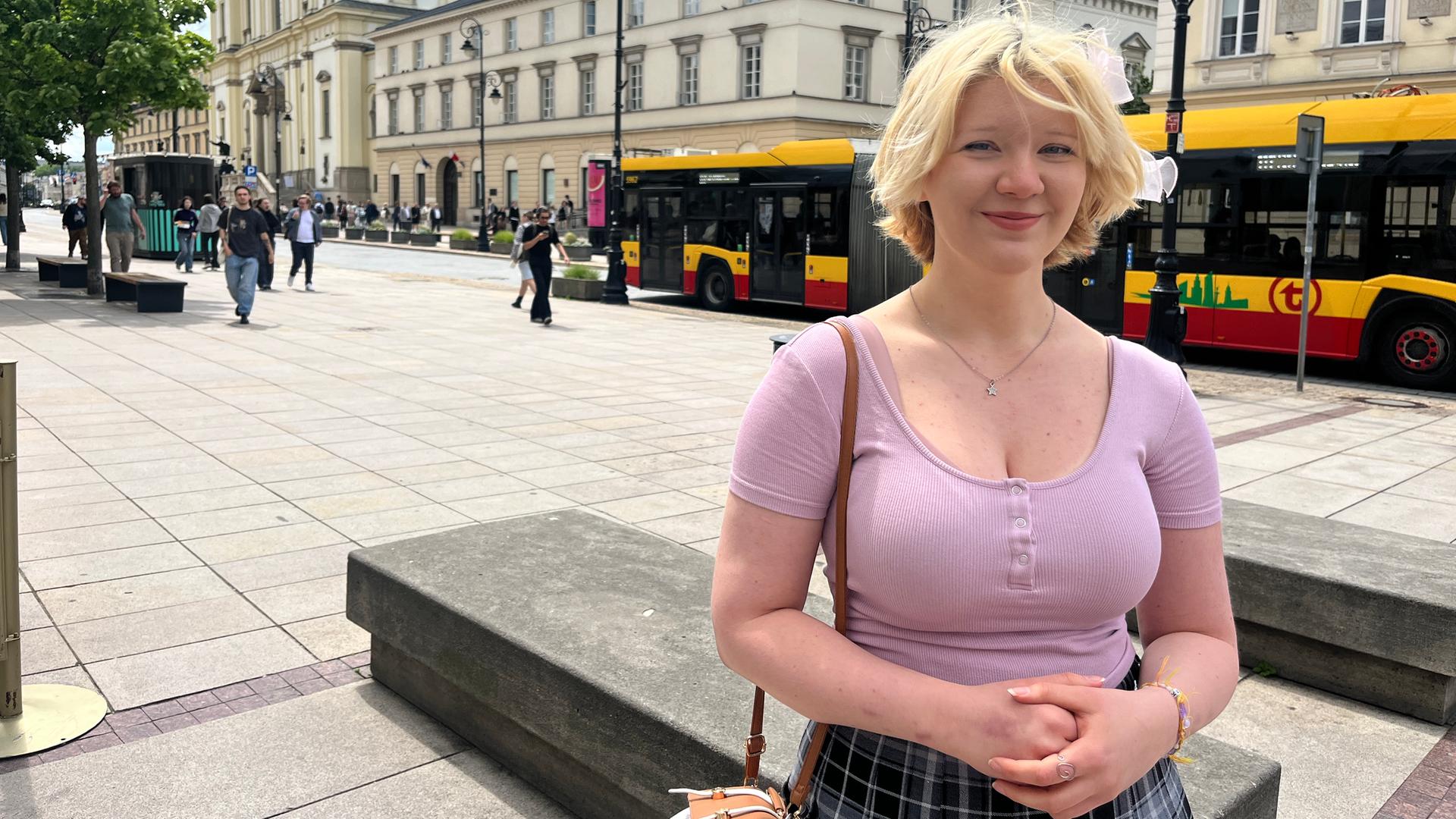 Kasandra Cieślak steht an einer breiten Straße in Warschau