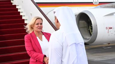 Bundesinnenministerin Nancy Faeser und der Emir von Katar schütteln sich die Hände. Im Hintergrund ein Flugzeug.
