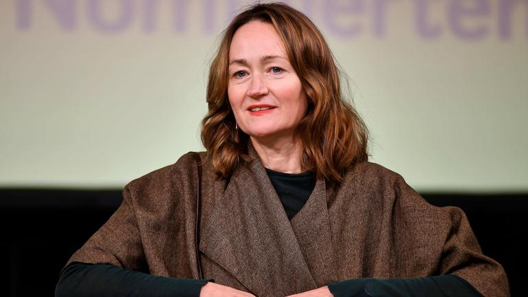 Porträtfoto einer Frau mittleren Alters mit langen rötlichen Haaren.