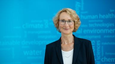 Prof. Katrin Böhning-Gaese lächelt in die Kamera, hinter ihr ein blauer Hintergrund