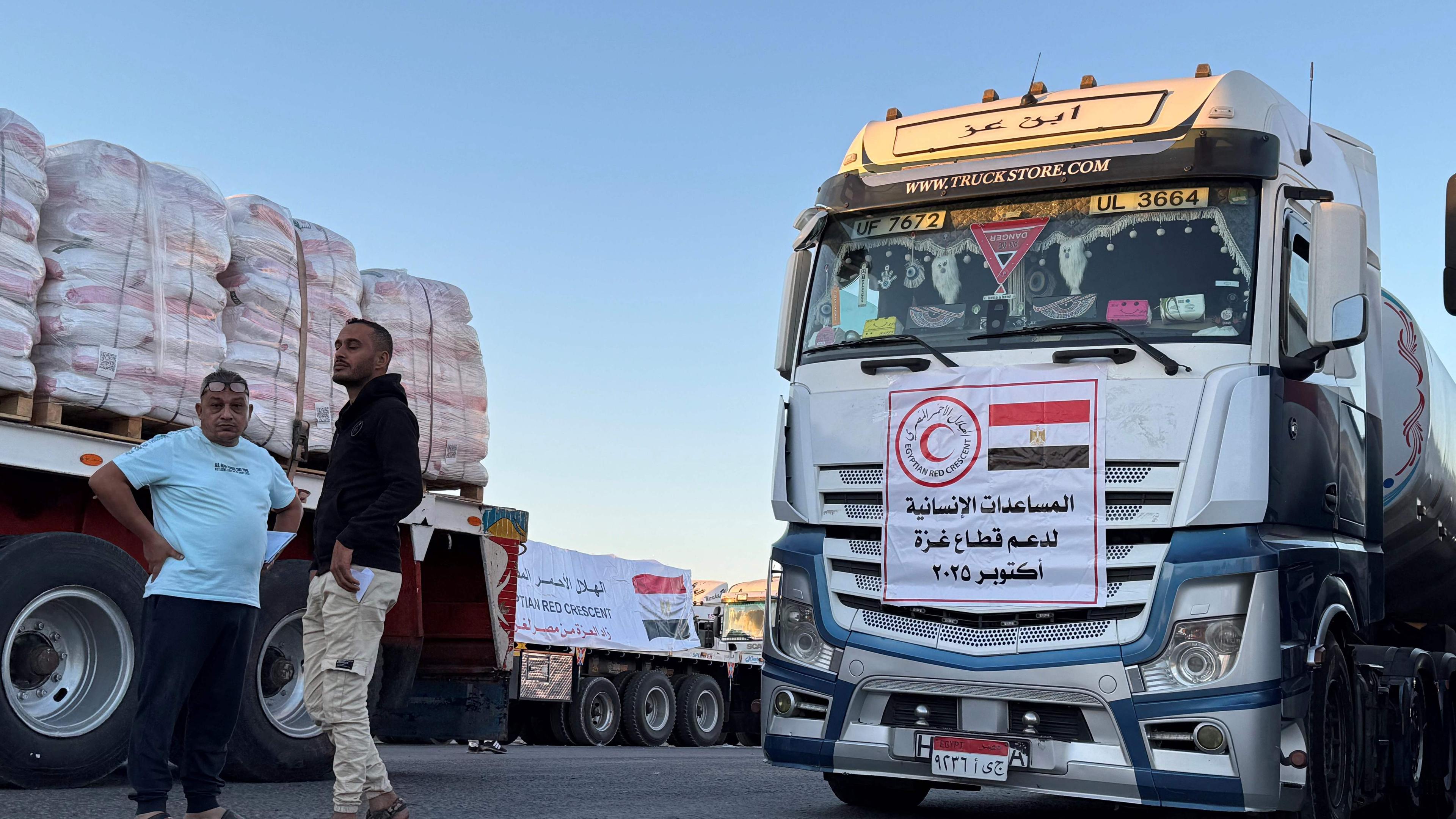 Mit humanitärer Hilfe beladene Lastwagen warten am frühen Morgen des 15. Oktober 2025 auf der ägyptischen Seite des Grenzübergangs Rafah auf die Überfahrt in den Gazastreifen, nachdem Israel angekündigt hatte, den Grenzübergang wieder zu öffnen, damit humanitäre Hilfe aus Ägypten in das palästinensische Gebiet gelangen kann.