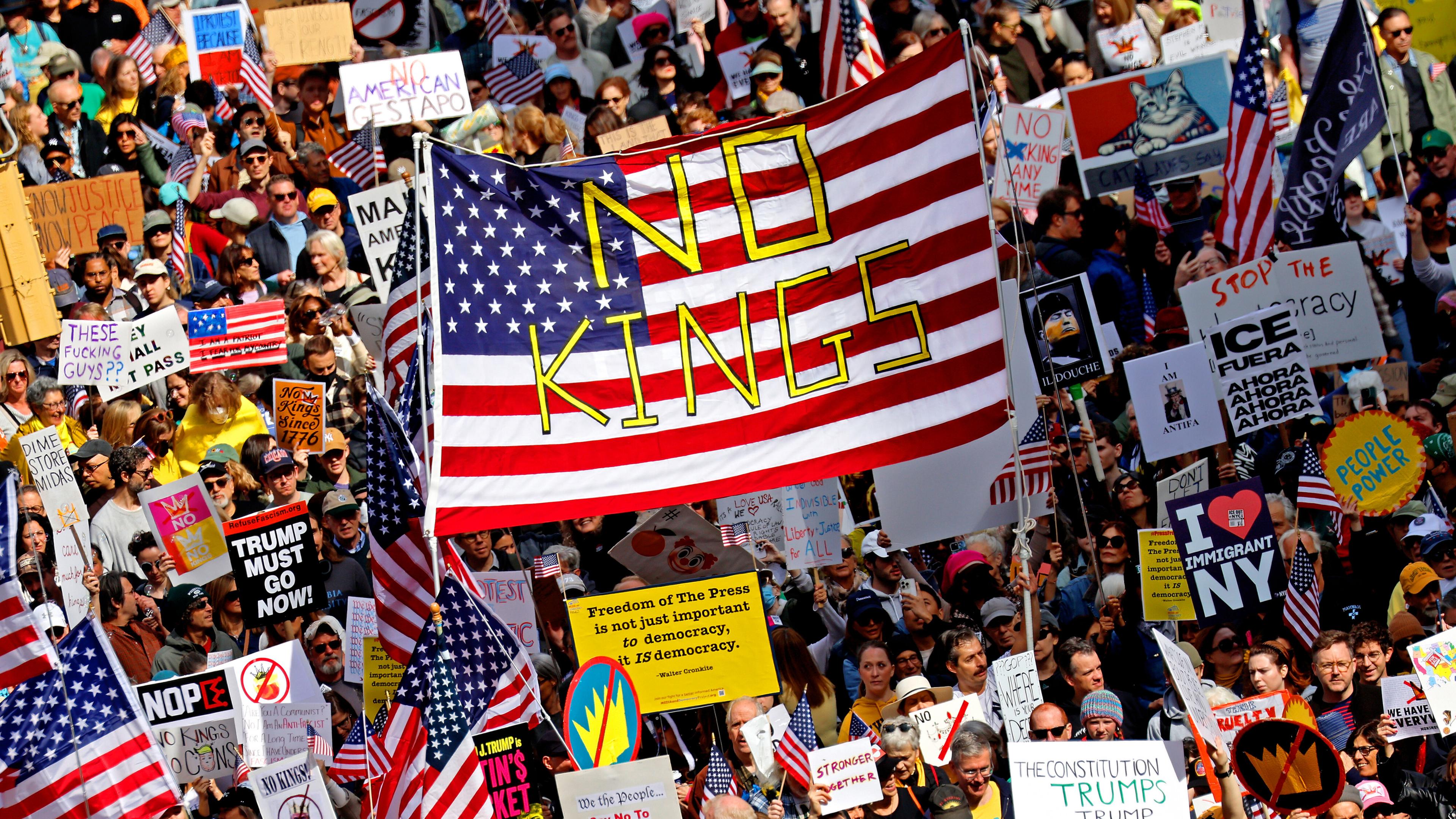 Auf der Seventh Avenue in New York demonstrieren Menschen mit Schildern gegen die Politik der Trump-Regierung.