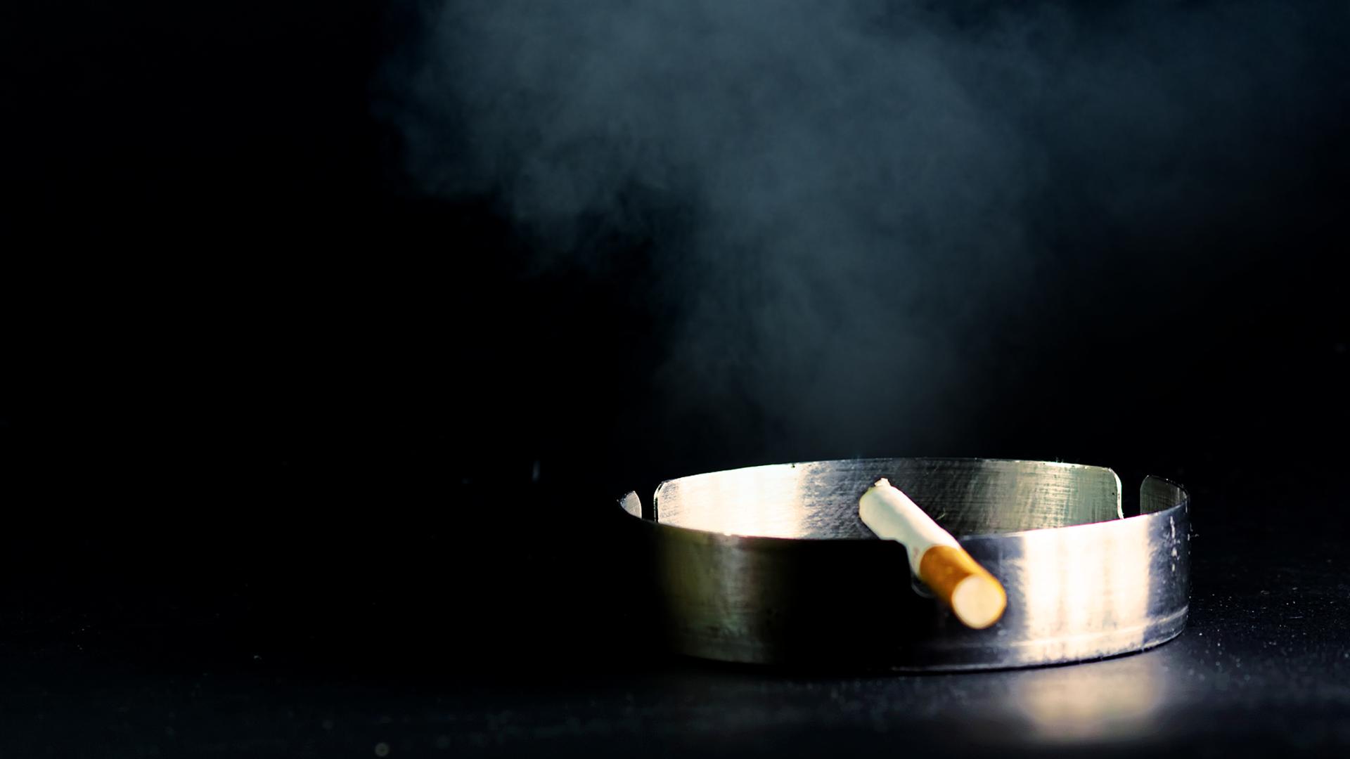 Auf dem Foto ist ein Aschenbecher mit einer Zigarette zu sehen. 