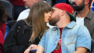  Footballer Travis Kelce und Sängerin Taylor Swift küssen sich.