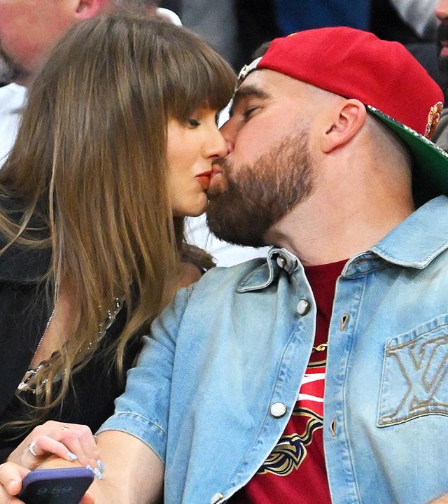  Footballer Travis Kelce und Sängerin Taylor Swift küssen sich.
