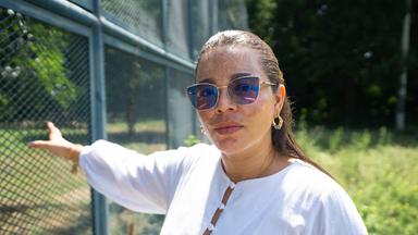 Kelly Diaz aus Kolumbien steht an einem Gefängniszaun.