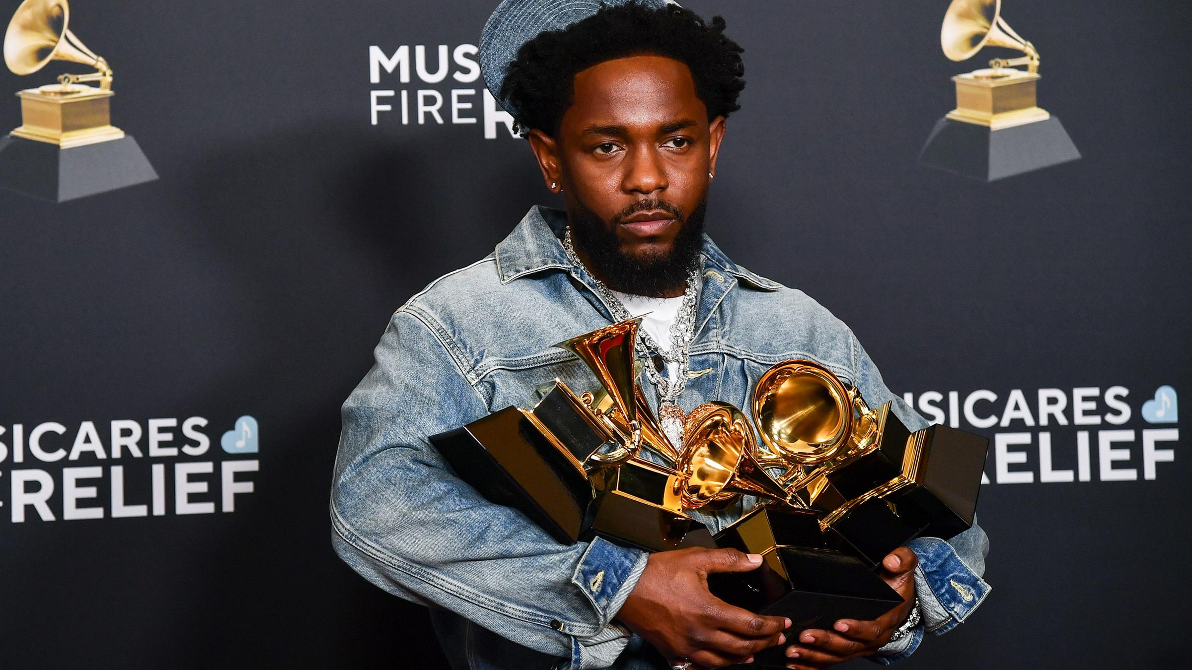 Der Rapper Kendrick Lamar mit Grammys in der Hand