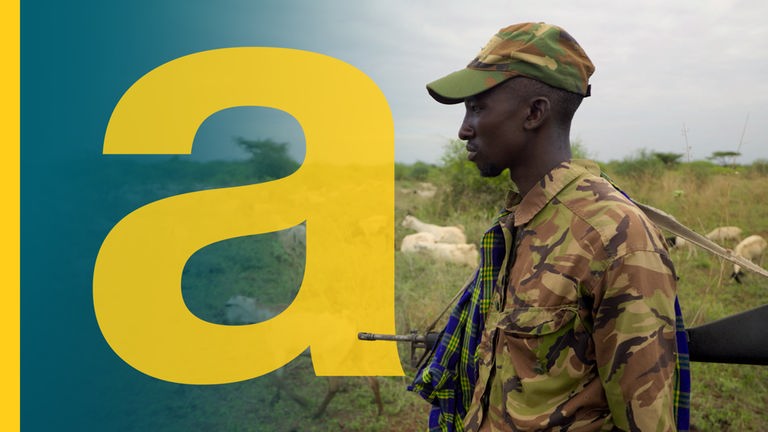 Der Wanderhirte Emathe Lokuto bewacht seine Ziegenherde mit einem Gewehr im Anschlag