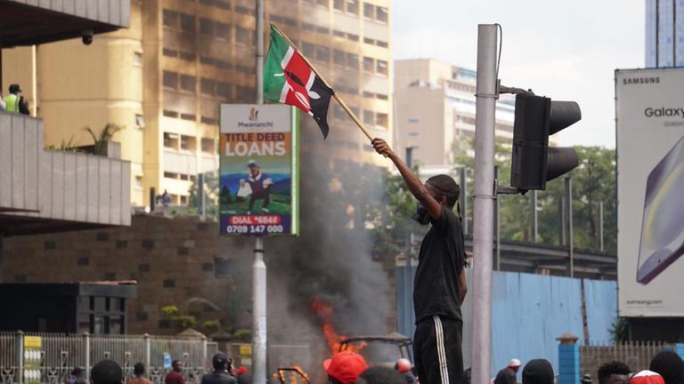 Ein junger Mann schwenkt die kenianische Flagge.