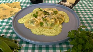 Kerbel-Ravioli mit Kohlrabi und Erbsen auf einem Teller.