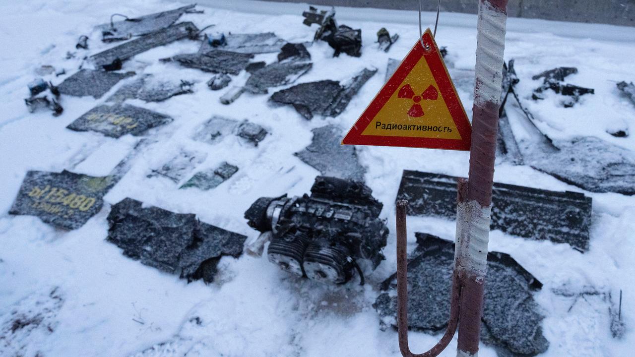 Fragmente eines Sprengsatzes, im Vordergrund ein Strahlenwarnschild, werden von ukrainischen Behörden nach einem Drohnenangriff auf das ehemalige Kernkraftwerk Tschernobyl in der Ukraine