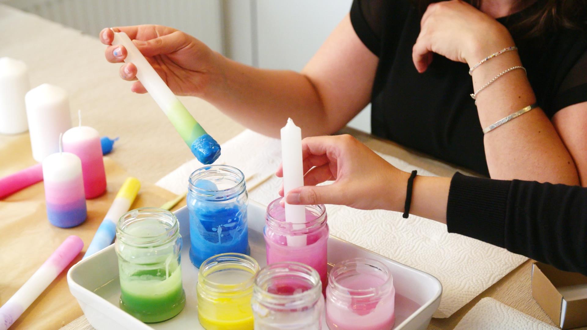 Kerzen selbst verschönern mit der Dip-Dye-Methode: Kerzen werden inbuntes Wachs getaucht.