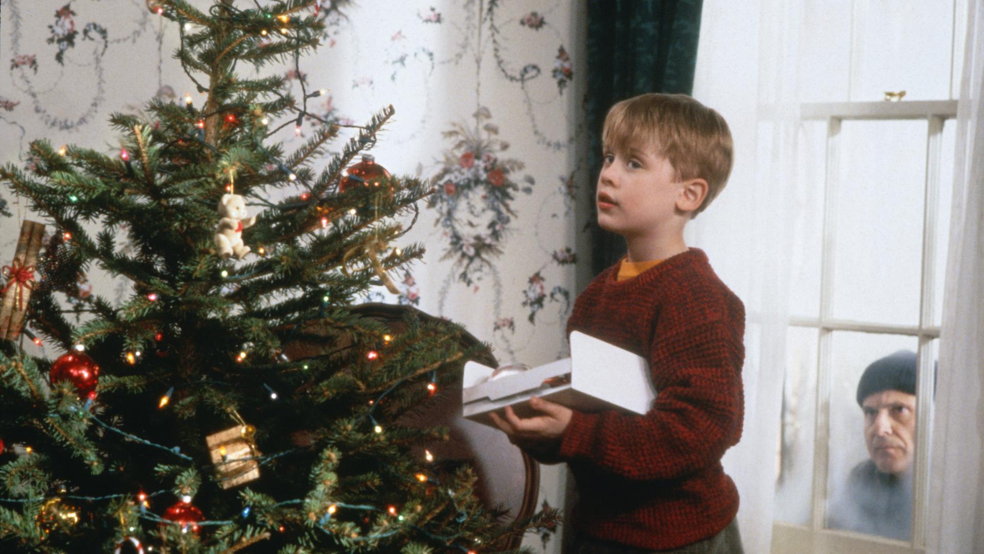 Während der nichtsahnende Kevin (Macaulay Culkin, l.) den Weihnachtsbaum schmückt, lauert Harry (Joe Pesci, r.) auf eine Gelegenheit, das Haus auszurauben, Szene aus dem Film «Kevin - Allein zu Haus»