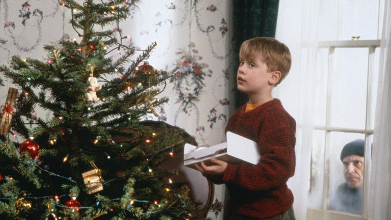 Während der nichtsahnende Kevin (Macaulay Culkin, l.) den Weihnachtsbaum schmückt, lauert Harry (Joe Pesci, r.) auf eine Gelegenheit, das Haus auszurauben, Szene aus dem Film «Kevin - Allein zu Haus»