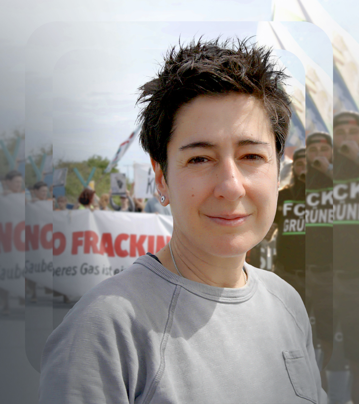 Dunja Hayali steht vor einer Demonstration mit Spruchbändern