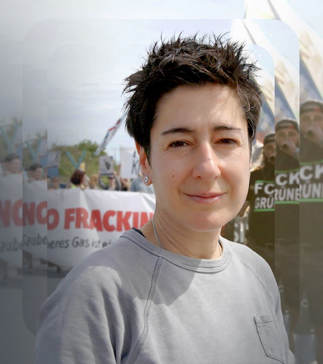 Dunja Hayali steht vor einer Demonstration mit Spruchbändern