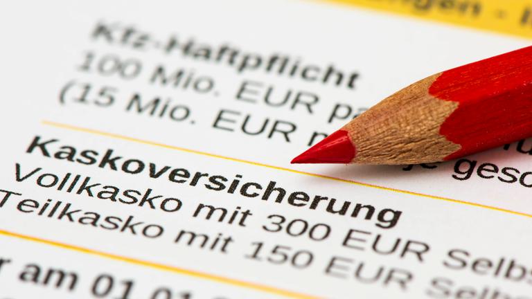 Ein Rotstift liegt auf der Beitragsrechnung für Kfz-Haftpflichtversicherung mit Angabe der Kaskoversicherung.