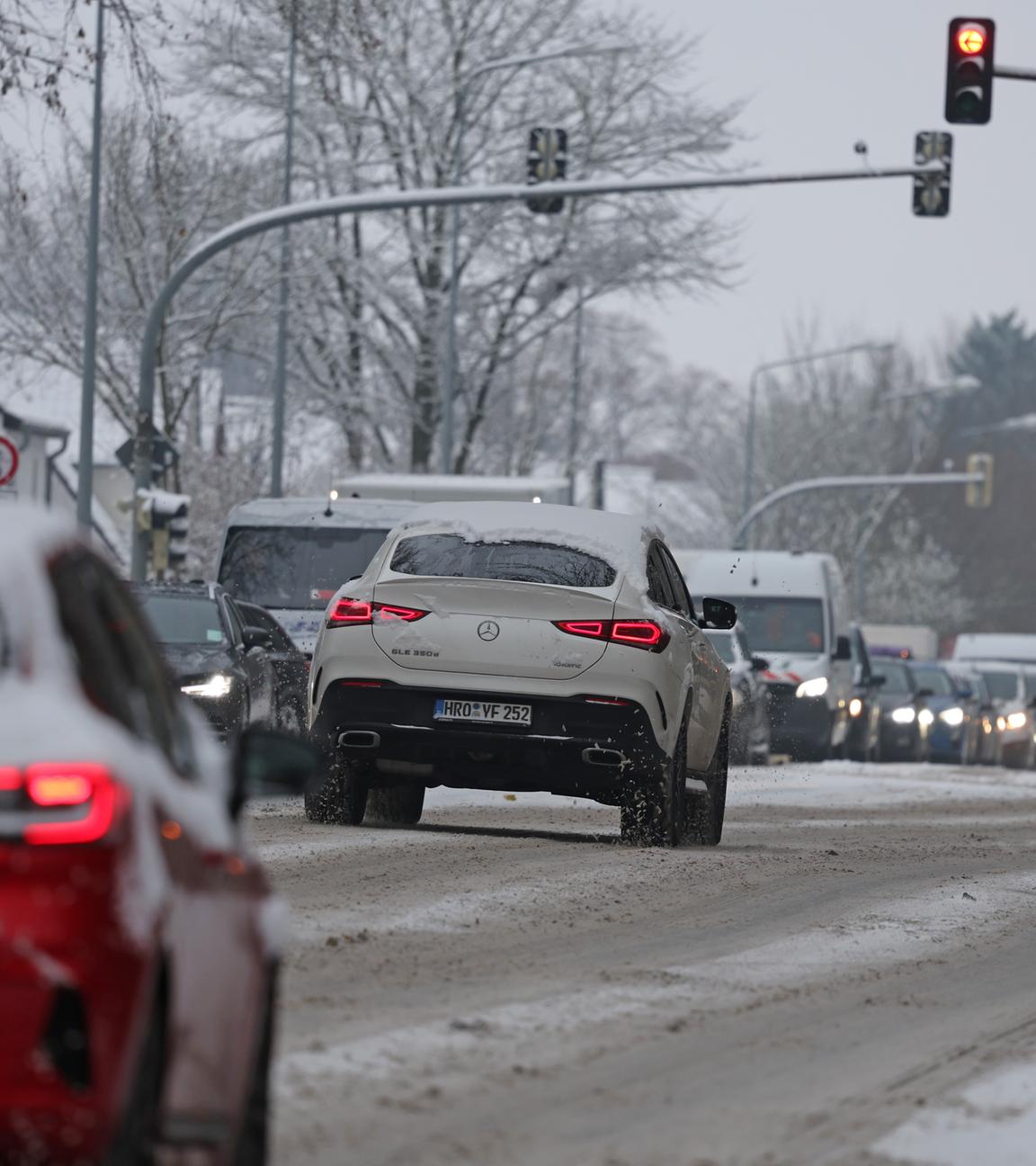 Schnee liegt auf den Zufahrtstraßen in die Stadt, die Autos stauen sich.