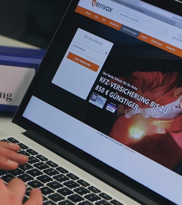 Person tippt auf einem Laptop, auf dem Bildschirm sieht man das Vergleichsportal "Verivox"