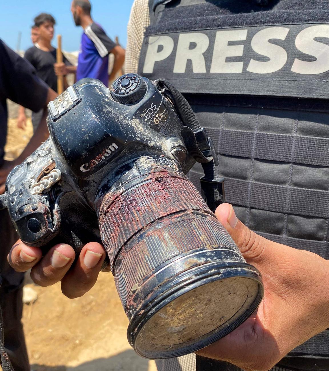 Ein Journalist hält eine blutverschmierte Kamera, die dem palästinensischen Fotojournalisten Hussam al-Masri gehörte, einem Reuters-Mitarbeiter, der bei einem israelischen Angriff auf das Nasser-Krankenhaus in Khan Yunis im südlichen Gazastreifen getötet wurde.