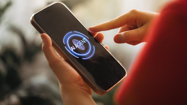 Eine Person, die ein Smartphone mit beleuchtetem Bildschirm nutzt, auf dem eine KI-Oberfläche zu sehen ist