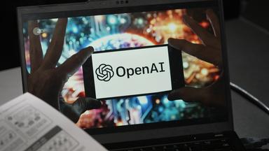 Open AI-Schriftzug auf Bildschirm eines Laptops