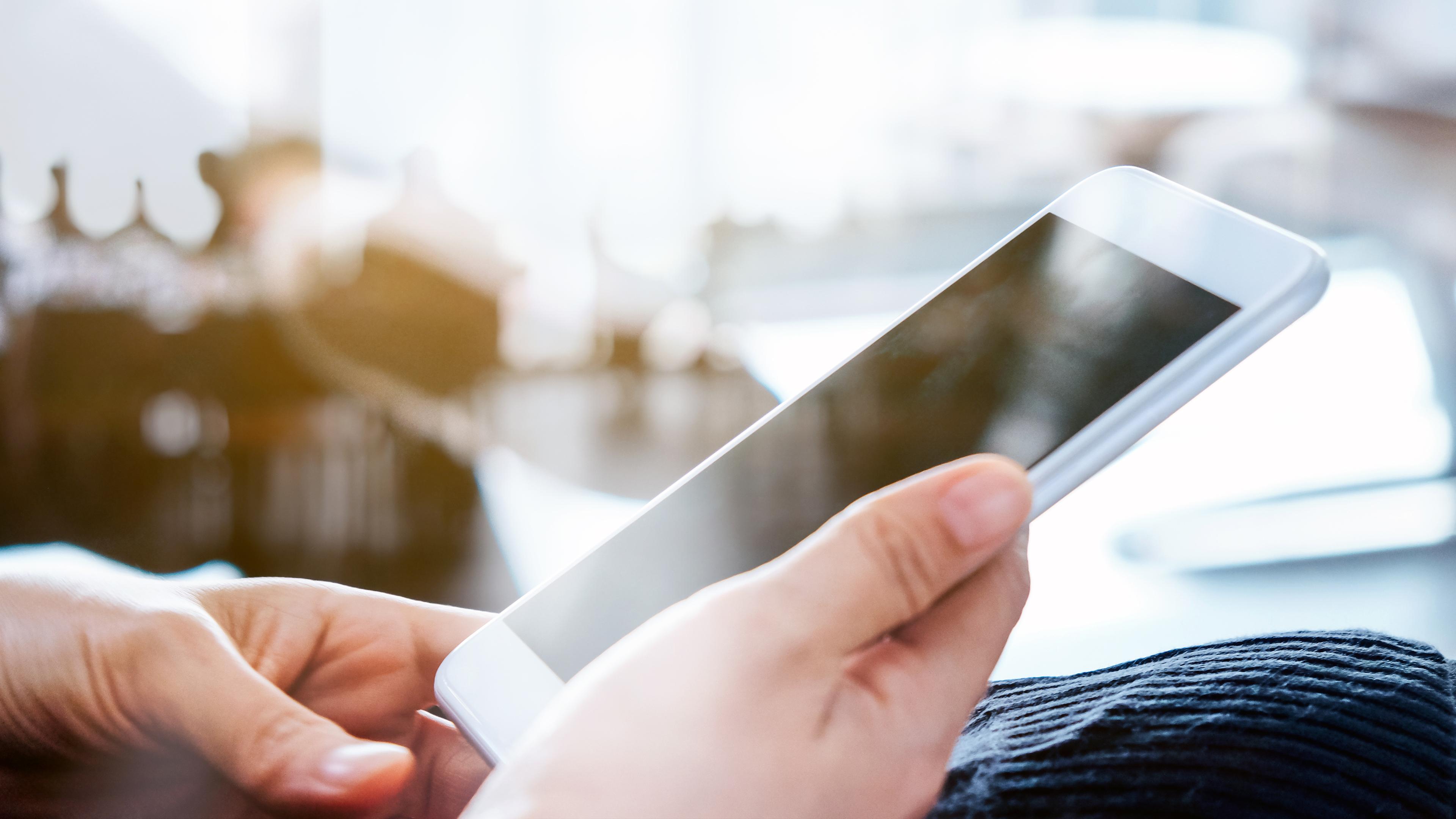 Eine Person hält ein Smartphone in ihren Händen