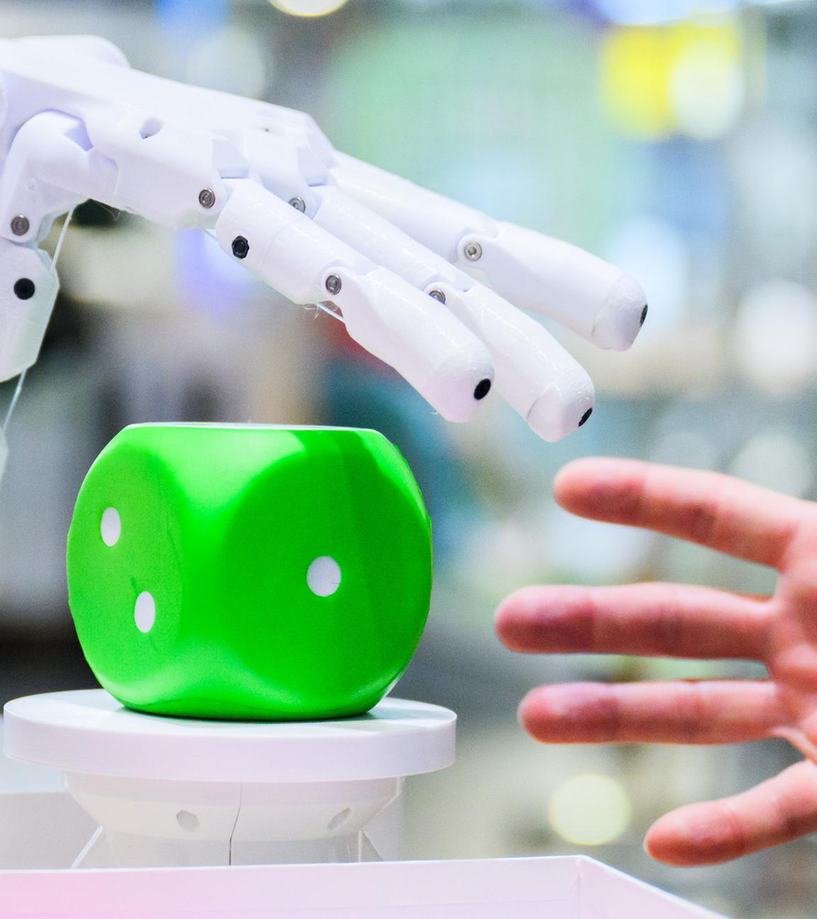 Ein Mann kommuniziert mit einem Ki-Roboter. (Symbolbild)