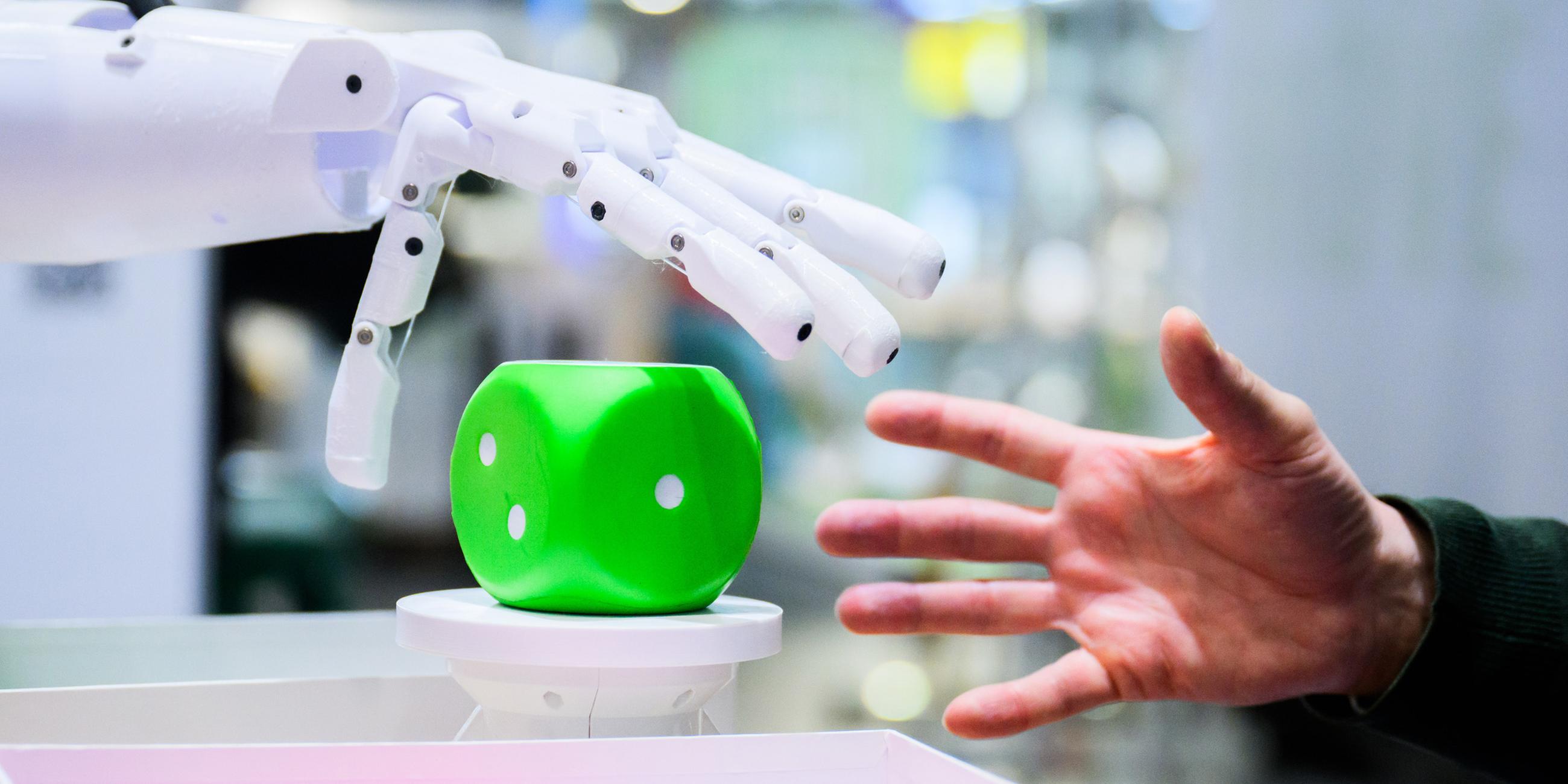 Ein Mann kommuniziert mit einem Ki-Roboter. (Symbolbild)
