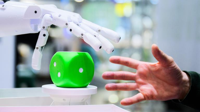 Ein Mann kommuniziert mit einem Ki-Roboter. (Symbolbild)