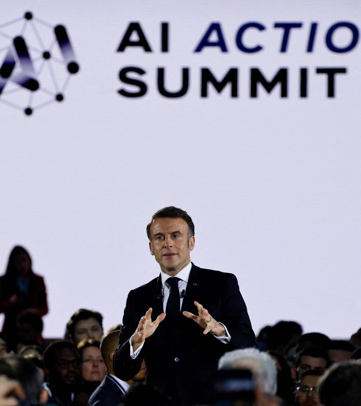 France's President Emmanuel Macron (C) delivers a speech during a closing event for the first day of the Artificial Intelligence (AI) Action Summit, at the Grand Palais, in Paris